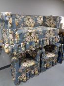 An early twentieth century three piece lounge suite in blue floral fabric