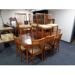 A circular continental mahogany extending table with four leaves and set of twelve rail backed