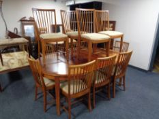 A circular continental mahogany extending table with four leaves and set of twelve rail backed