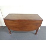 An antique mahogany drop leaf table