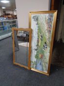 A blond oak framed leaded glass mirror together with a gilt frame tapestry depicting a farming