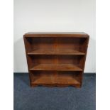 A set of stained pine open bookshelves.
