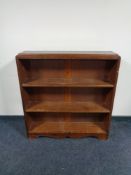 A set of stained pine open bookshelves.