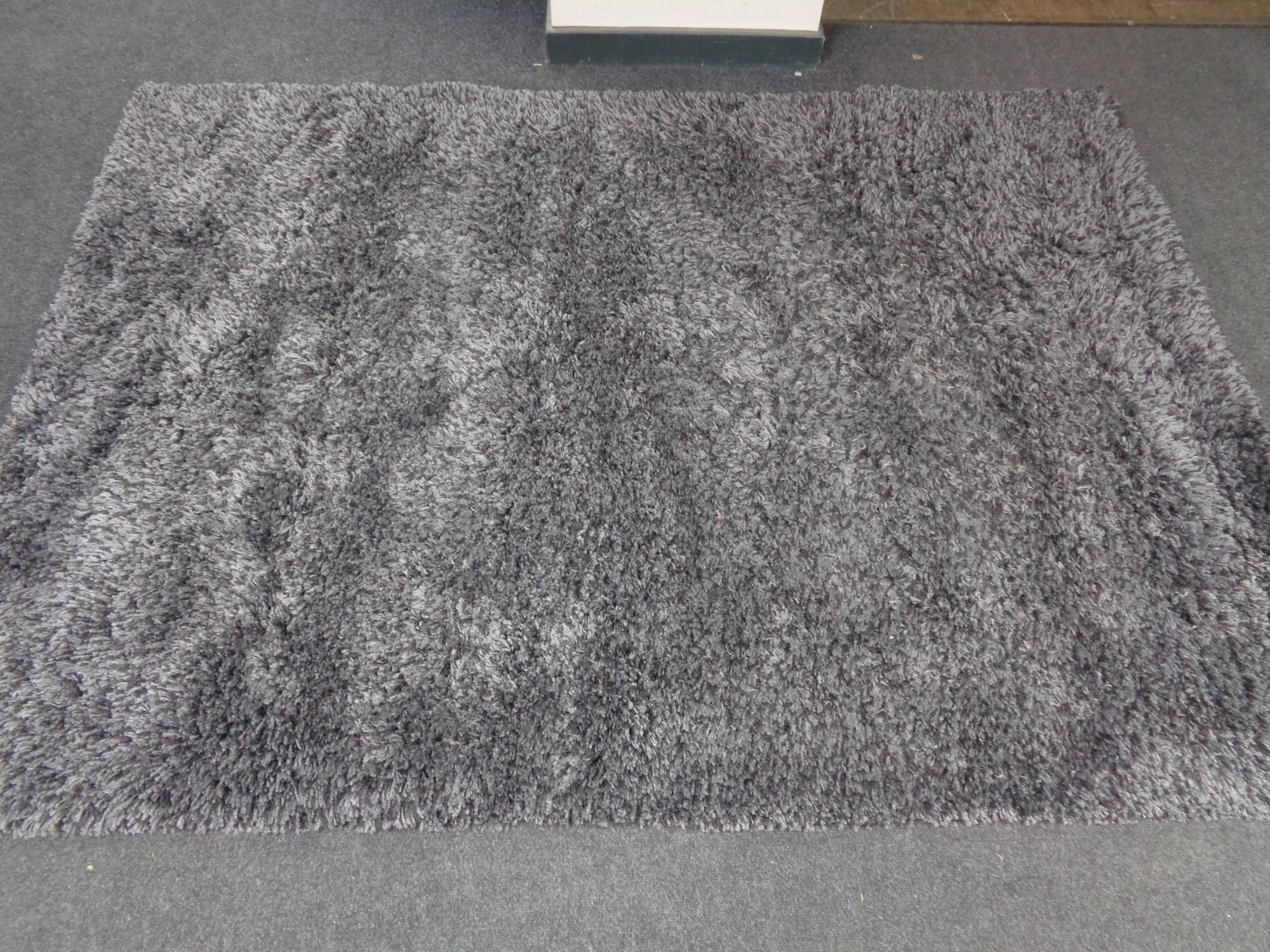 A contemporary grey shaggy pile rug.