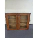 An antique pine double door glazed bookcase