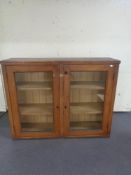 An antique pine double door glazed bookcase