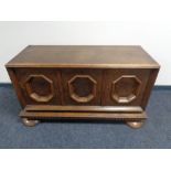 An early 20th century oak three door low sideboard with walnut panel doors.