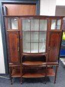 A late Victorian inlaid mahogany display cabinet with undershelf on raised legs