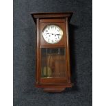 An early 20th century oak cased wall clock with silvered dial.