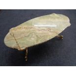 A shaped onyx topped coffee table on ornate brass base.