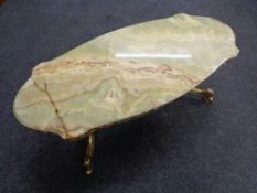 A shaped onyx topped coffee table on ornate brass base.