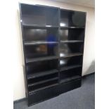 A pair of contemporary black high gloss open bookshelves