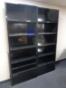 A pair of contemporary black high gloss open bookshelves