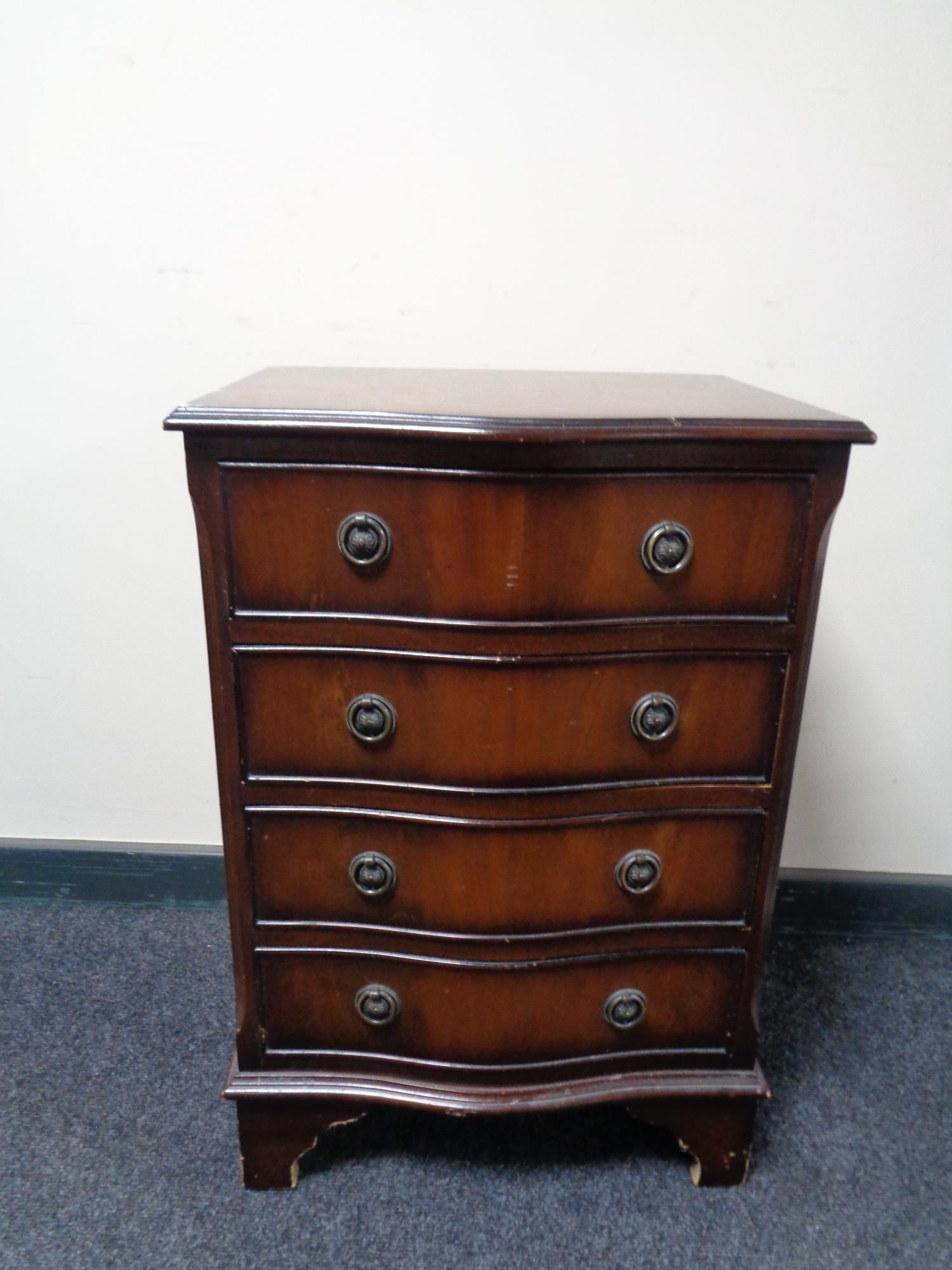 A Georgian style mahogany serpentine fronted four drawer chest