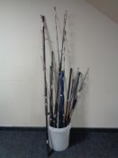 A bucket containing a large quantity of spinning rods,