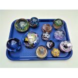 A tray of twelve assorted glass paperweights