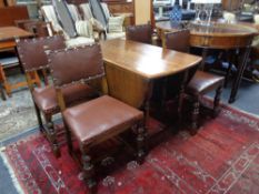 An Edwardian oak gateleg table together with a set of four dining chairs upholstered in a brown