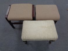 A carved beech dressing table stool together with two further footstools in beige fabric