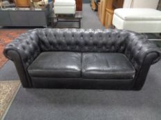 A Chesterfield black buttoned leather three seater settee