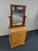 A pine three drawer bedside chest together with a dressing table mirror