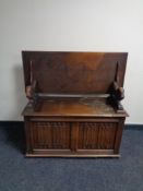 A carved oak monk's bench,