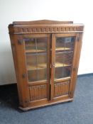 A 20th century oak leaded glass double door bookcase