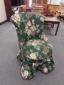 An early twentieth century shaped backed bedroom chair in green floral fabric on mahogany legs