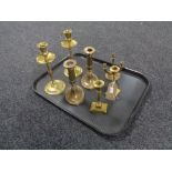 A tray containing three pairs of twentieth century brass candlesticks together with a three way