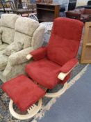 A contemporary beech framed red upholstered swivel relaxer armchair with stool