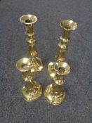 Two pairs of antique brass candlesticks.