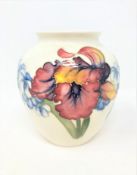 A Walter Moorcroft baluster vase on white ground, height 13cm.