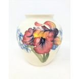 A Walter Moorcroft baluster vase on white ground, height 13cm.