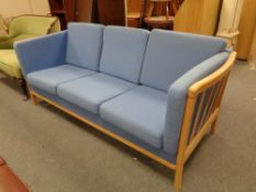 A wood framed Danish three seater settee upholstered in blue fabric