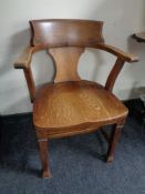 An Edwardian oak captain's style chair