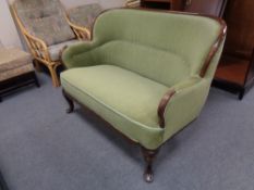 An antique mahogany framed settee in green dralon