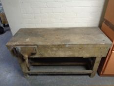 A mid century wooden work bench with vice, 135cm long by 55cm deep by 71cm high.