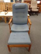 A mid century teak framed high backed armchair in blue fabric with matching footstool