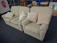 A fabric upholstered two seater settee with matching armchair and four loose cushions