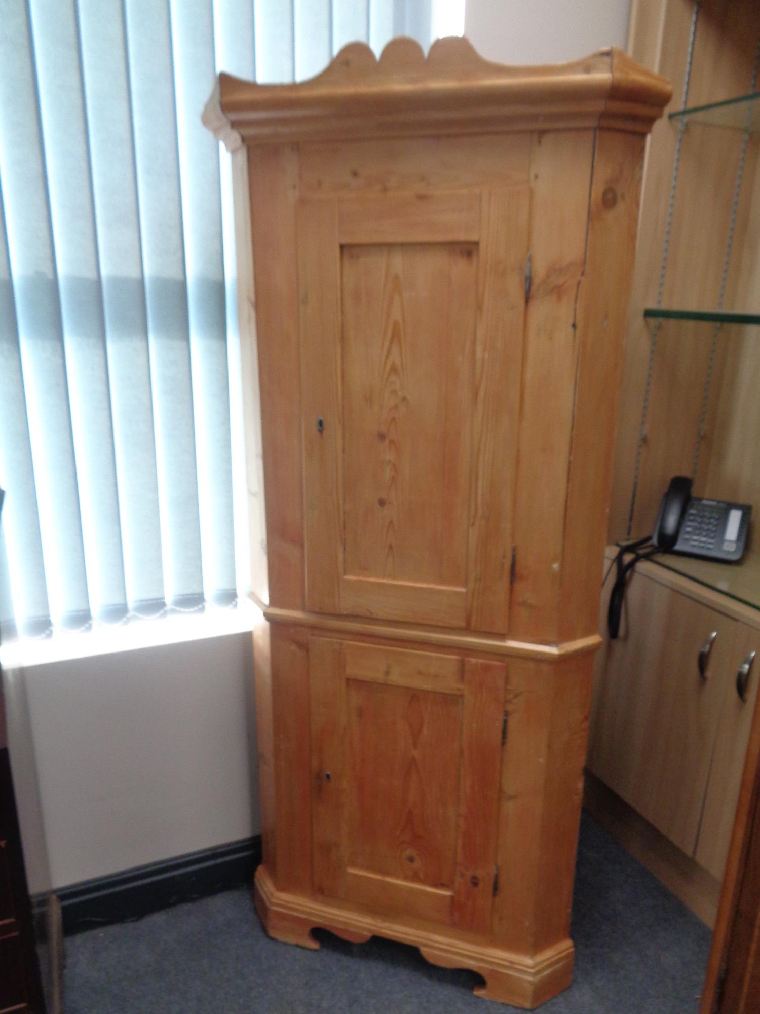 An antique pine double door corner cabinet