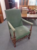 An early twentieth century oak framed armchair in green fabric