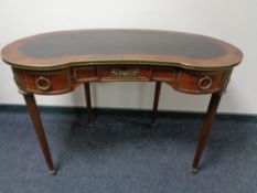 A Louis XV style kidney shaped writing desk with leather inset panel with brass mounts on raised,