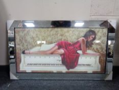 A framed print of a lady in red dress reclining on grand piano with glitter decoration in mirrored