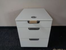 A three drawer underdesk filing chest with combination lock