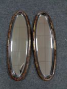 A pair of Edwardian oval Chinoiserie framed bevelled edge mirrors,