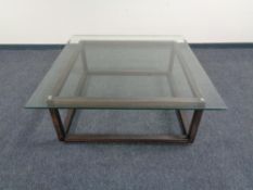A contemporary oversized glass topped bevelled edge coffee table on wooden base