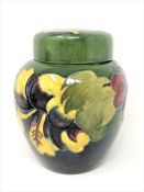 A Walter Moorcroft 'Hibiscus' ginger jar and cover on green ground, WM signature, height 15cm.