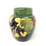 A Walter Moorcroft 'Hibiscus' ginger jar and cover on green ground, WM signature, height 15cm.