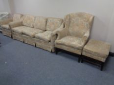A four piece lounge suite in floral fabric comprising of three seater settee, armchair,