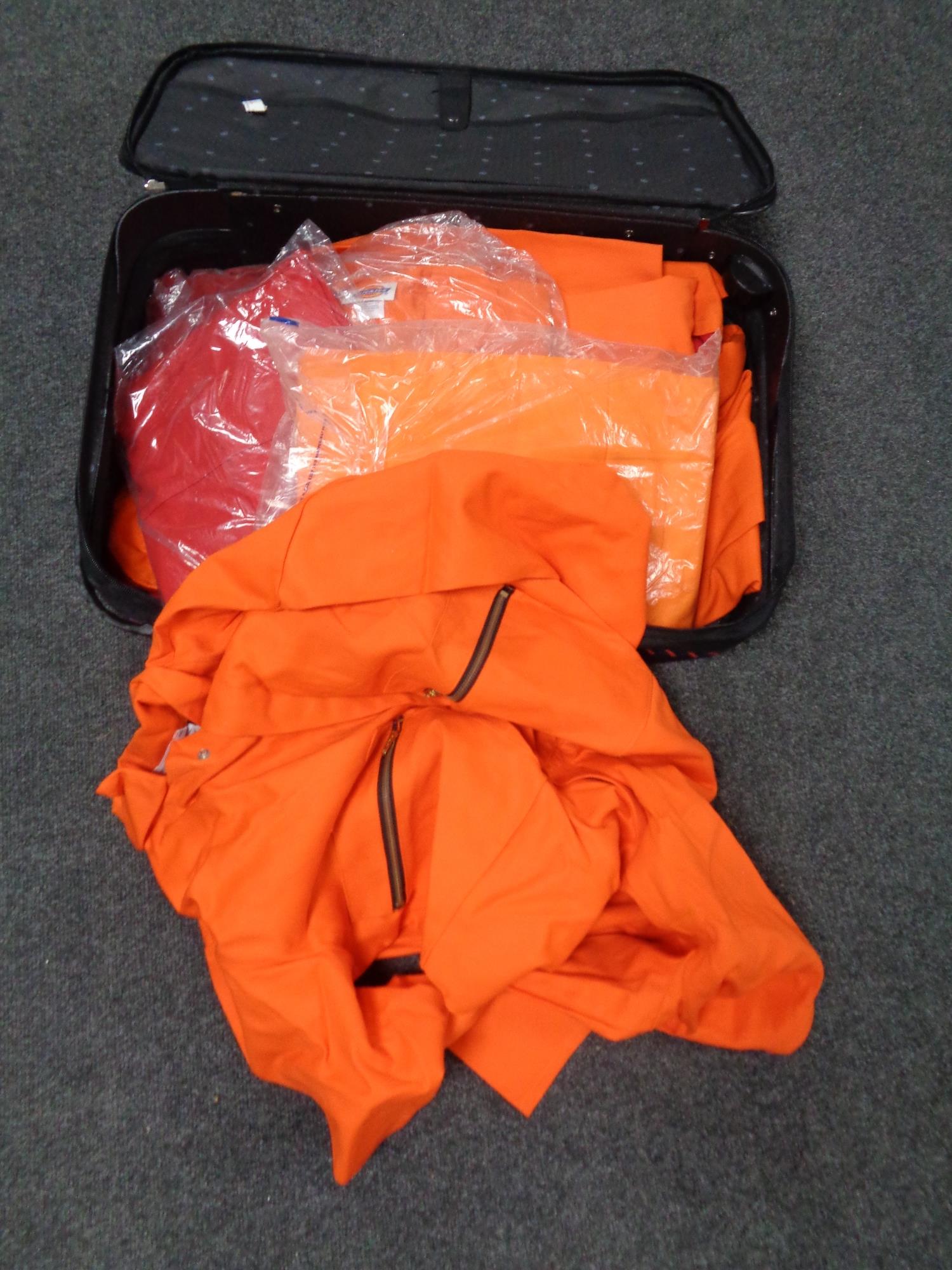 A luggage case containing Dickies overalls.