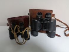 Two sets of early twentieth century leather cased field glasses.